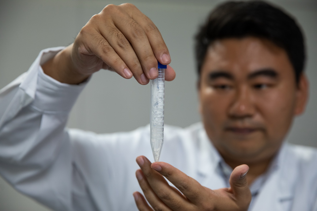 中國科學院天津工業生物技術研究所蔡韜副研究員在實驗室展示人工合成澱粉樣品（9月16日攝）。