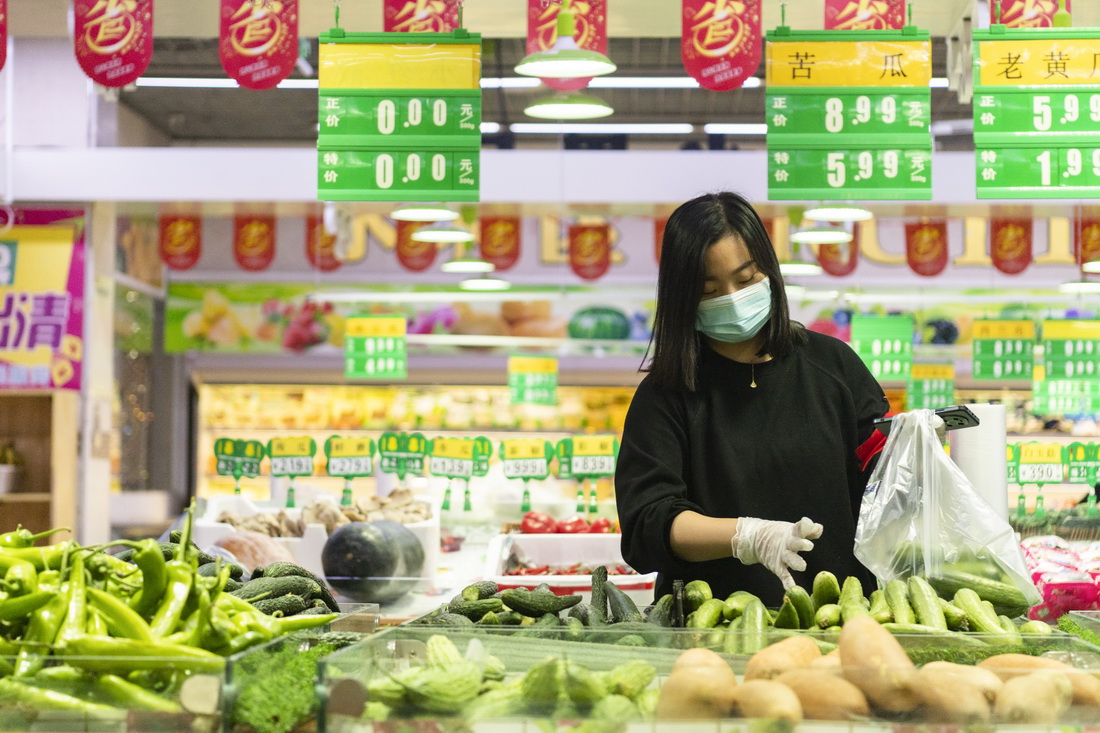 9月25日，哈爾濱市巴彥縣一大型超市工作人員為線上下單的居民挑選果蔬。新華社記者 謝劍飛 攝