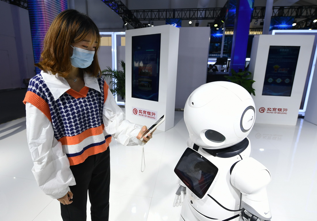9月25日，在中關村論壇展覽（科博會）現場，觀眾體驗通過服務機器人辦理普惠金融相關業務。新華社記者  任超 攝