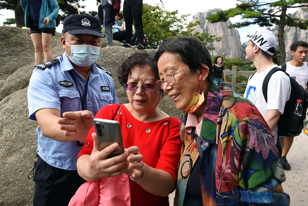 9月26日，胡晓春在黄山风景区回答游客咨询。