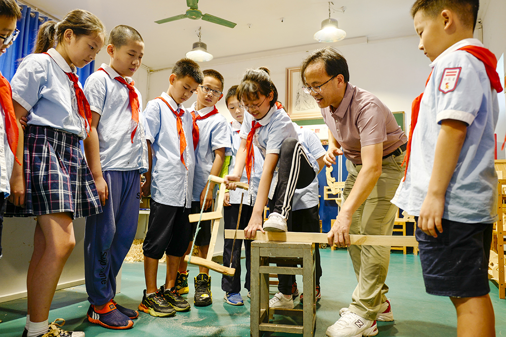 9月27日，在鐵路小學的小魯班社團活動室內，老師指導學生學習使用鋸子。