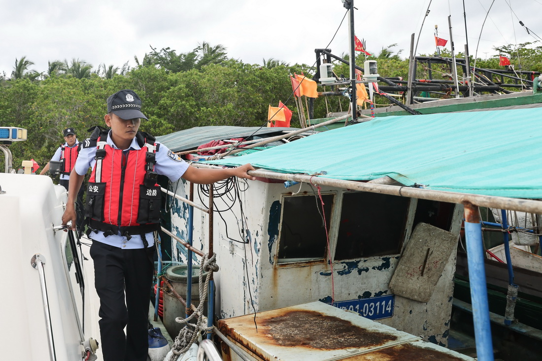 10月7日，在海南三亞鐵爐港，海南省公安廳海岸警察總隊第四支隊后海海岸派出所的民警對漁船進行防台風檢查。