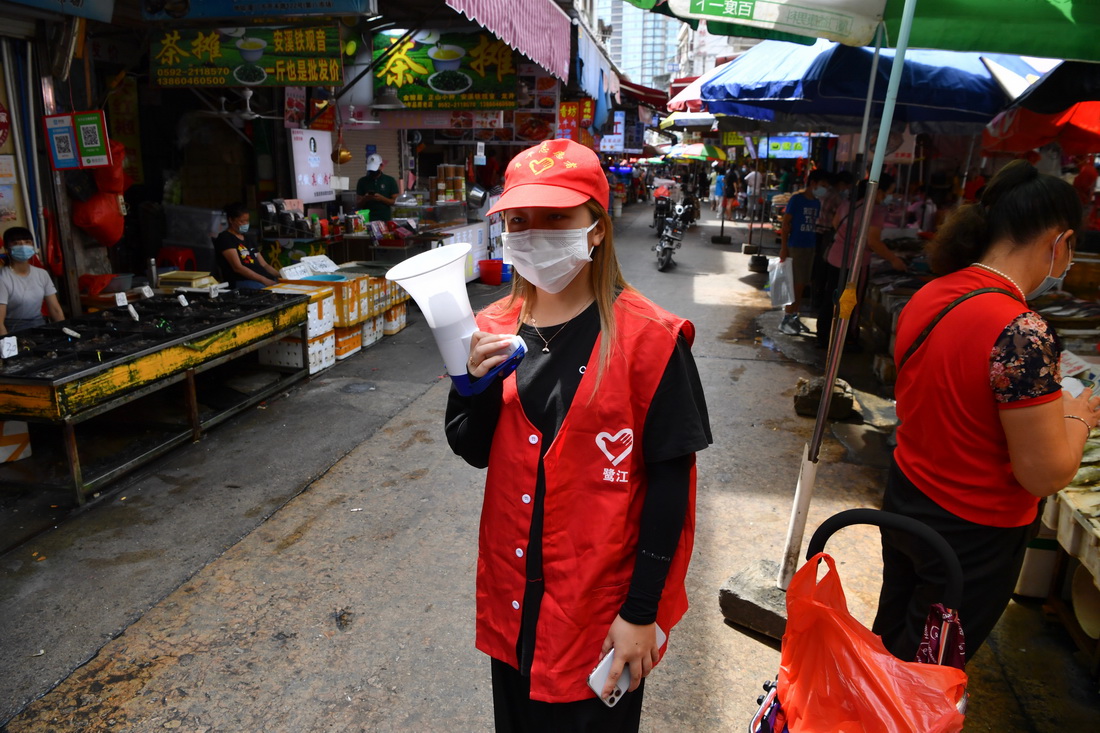 10月8日，志愿者在厦门开禾市场提醒市民佩戴口罩。