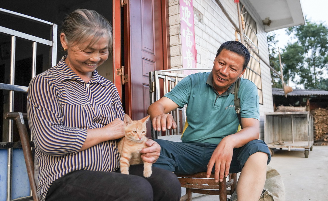 9月28日，雙峰郵政所的郵遞員吳文清（右）為村民派送一隻貓咪。這名獨居的村民此前委托吳文清為她選購一隻寵物貓作伴。
