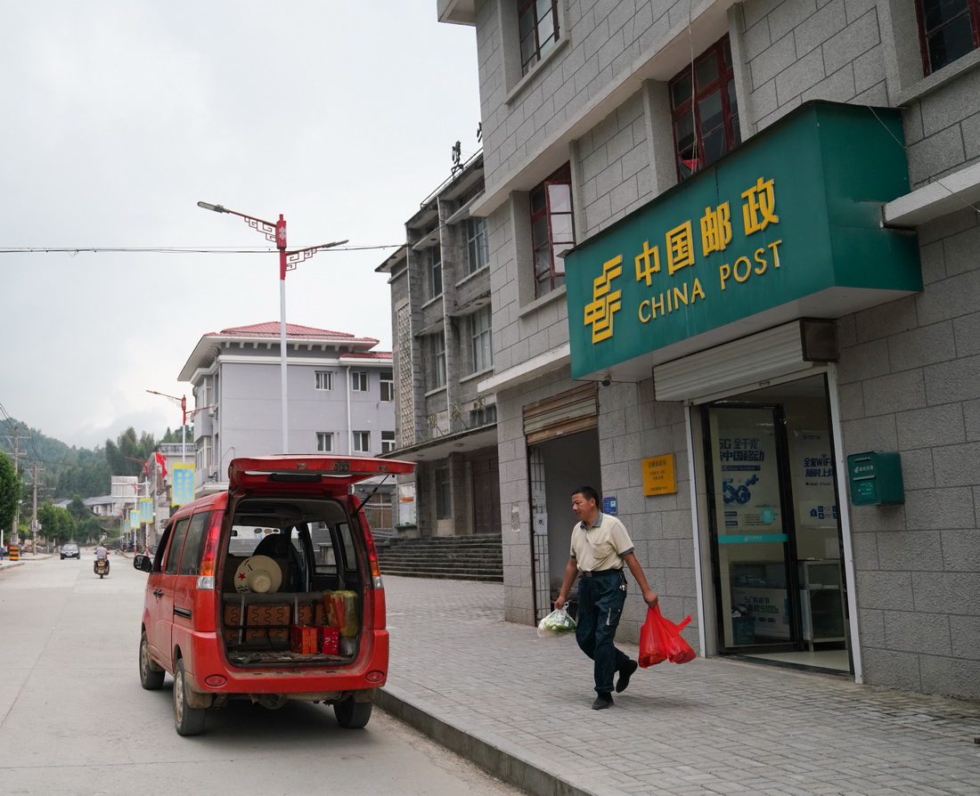 10月6日，雙峰郵政所的郵遞員吳文清即將離開郵政所，為村民送貨。