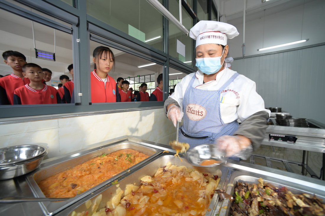 10月12日，在貴州省遵義市綏陽縣風華鎮中心學校食堂，工作人員在給學生打菜。新華社記者 楊楹 攝