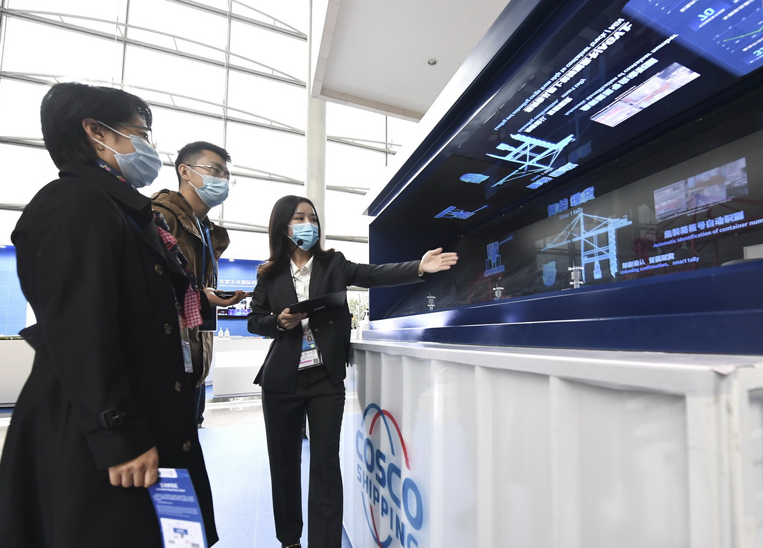 10月14日，在北京国家会议中心，工作人员向参观者介绍5G智慧港口动态演示。