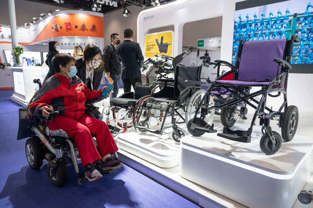 10月16日，在中國國際福祉博覽會上，工作人員為一名觀眾介紹新款輪椅。