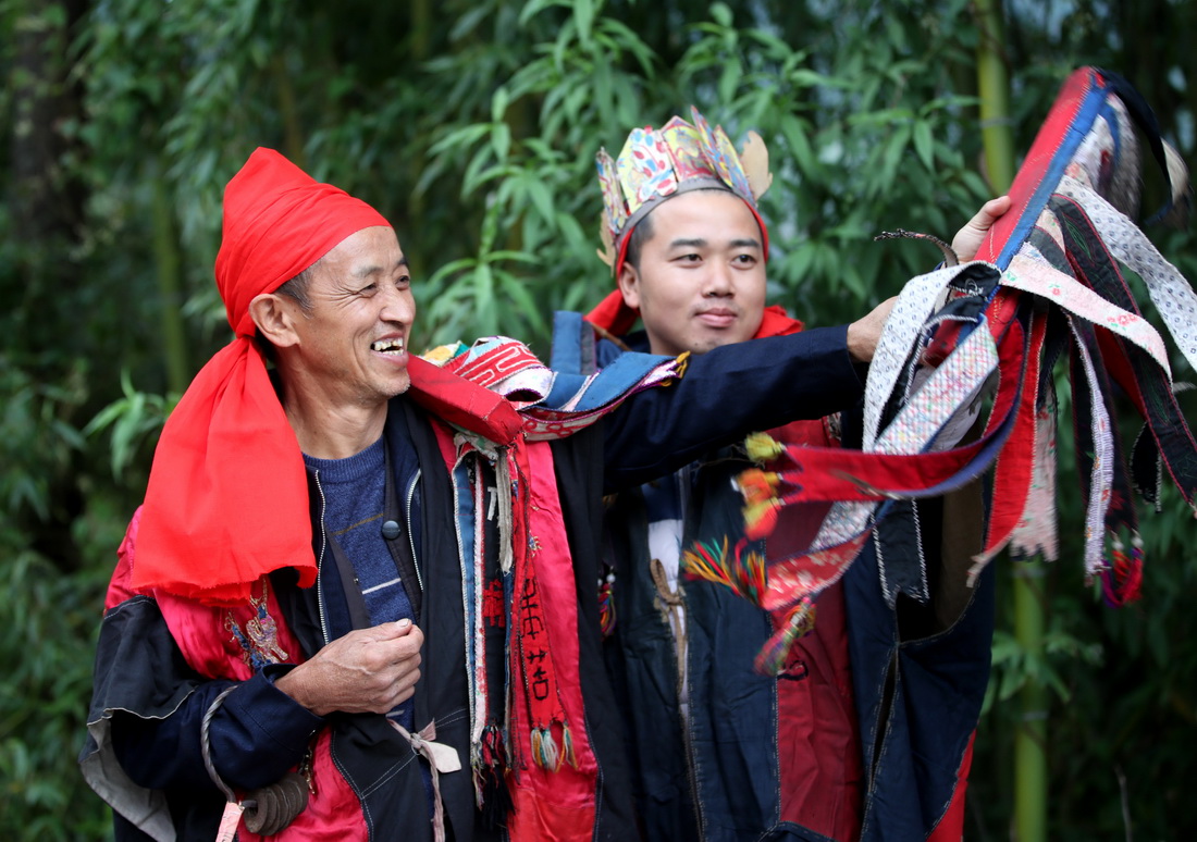 10月17日，肖光华（左）指导徒弟表演思州傩戏傩技。新华社发（胡攀学 摄）