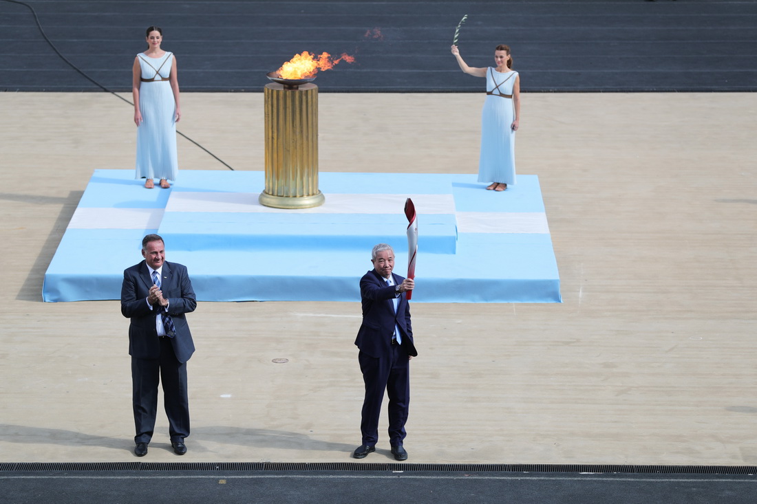 10月19日，北京冬奧組委特別代表、北京冬奧組委副主席於再清（前右）展示北京冬奧會火炬。