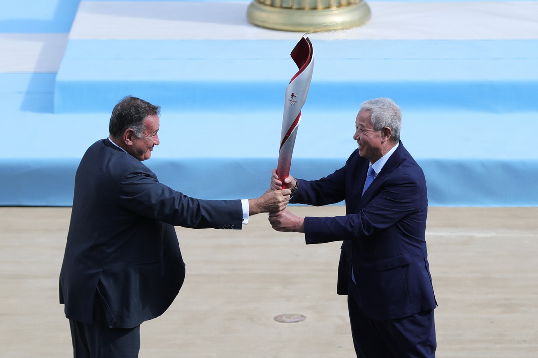 10月19日，希臘奧委會主席斯皮羅斯·卡普拉洛斯將火炬交給北京冬奧組委特別代表、北京冬奧組委副主席於再清（右）。