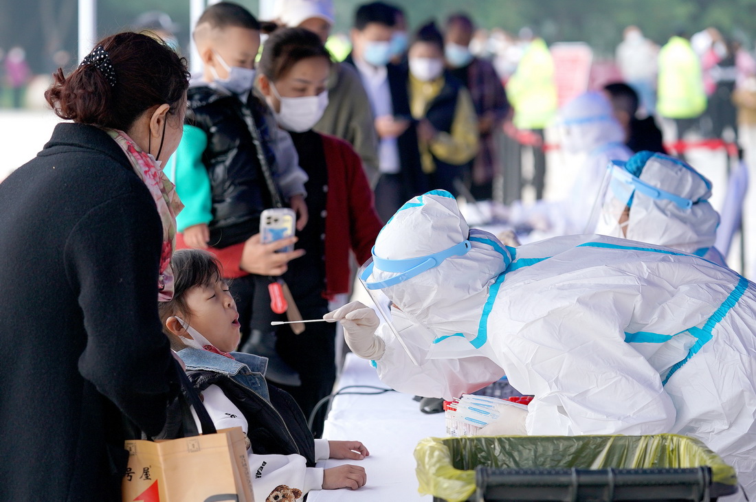 10月19日，市民在西安市曲江池遗址公园外一核酸检测点进行核酸检测。