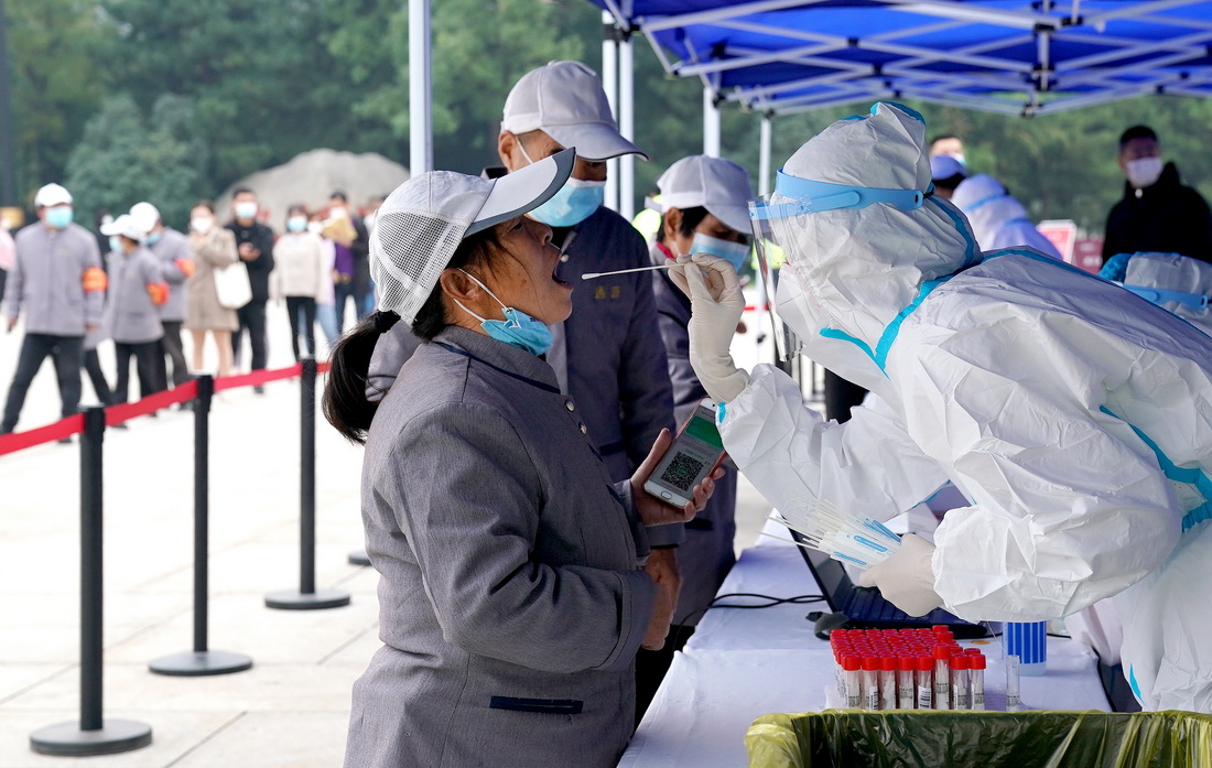 10月19日，市民在西安市曲江池遗址公园外一核酸检测点进行核酸检测。