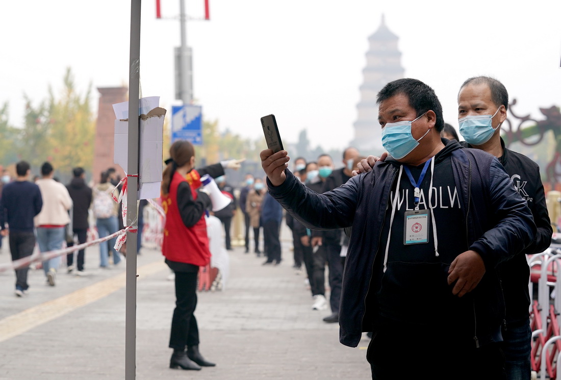 10月19日，市民在西安市雁塔北路一核酸检测点排队进行核酸检测。
