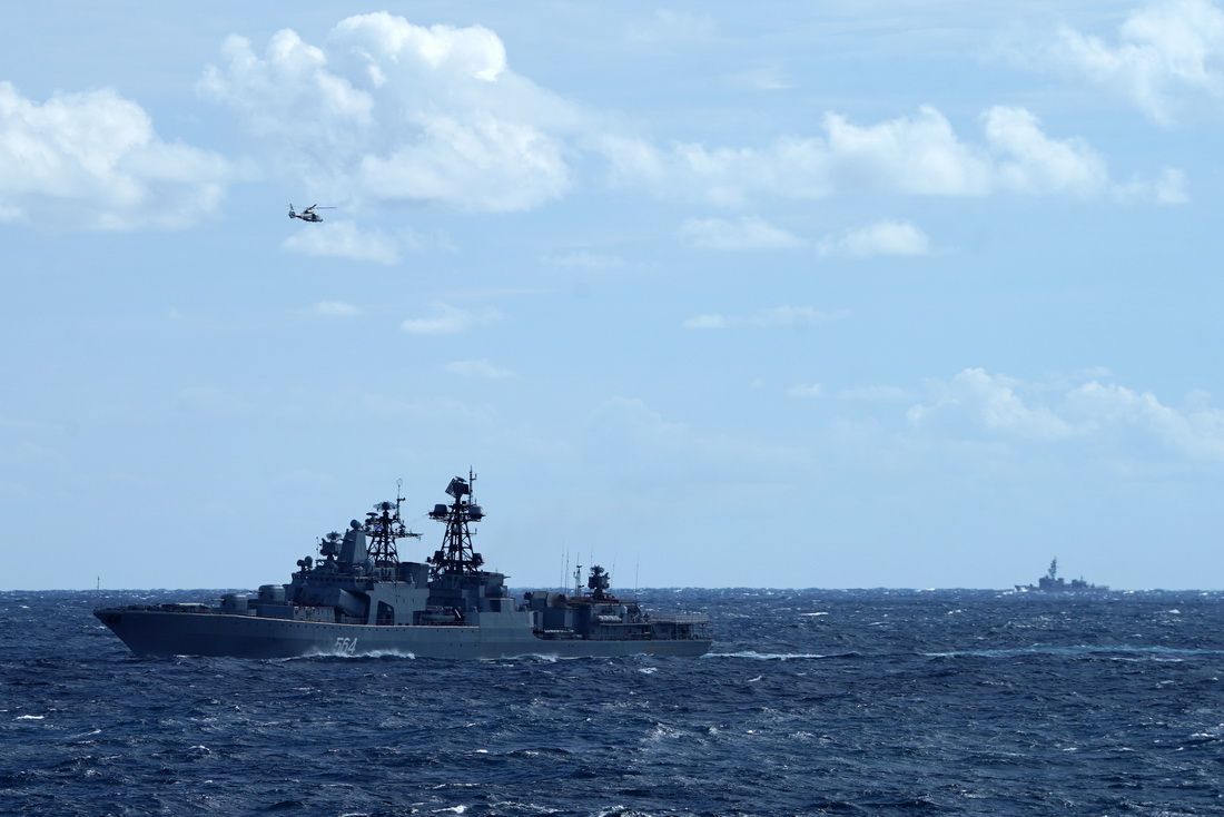 中俄海军首次海上联合巡航期间，日自卫队舰艇（右）对俄大型反潜舰（左下）和中方舰载直升机（左上）联合训练进行跟踪侦察（10月23日摄）。新华社发（孙金钢 摄）