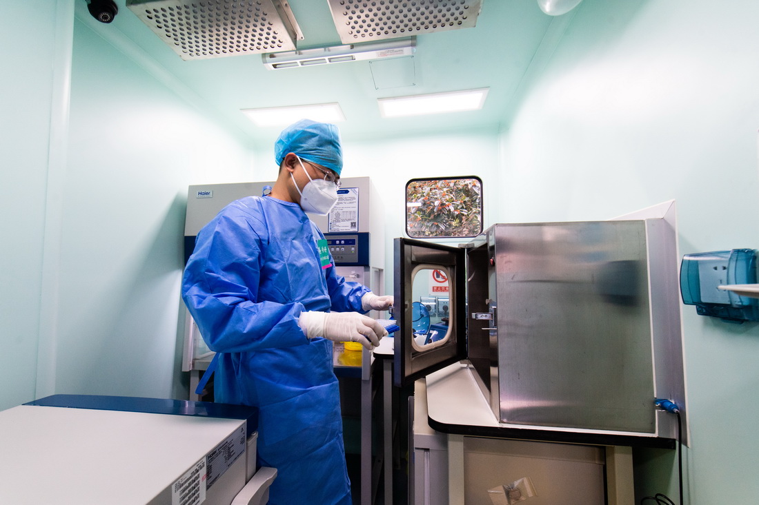 10月25日，在P2+移動生物檢測車上，中南大學湘雅二醫院醫生蔣傳好准備把配置好的檢測試劑從試劑准備間傳遞到樣本制備間。