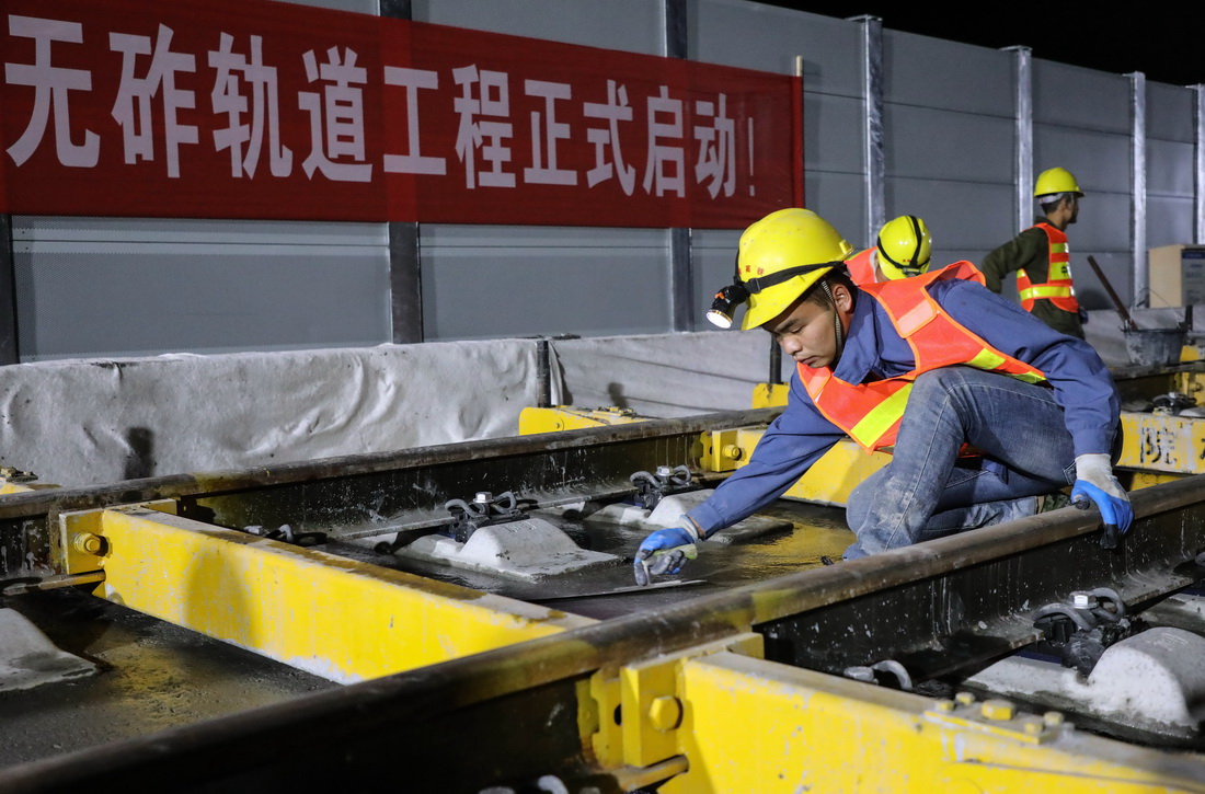 10月27日，在贵南高铁广西段八仙双线特大桥施工现场，施工人员对道床面进行平整。