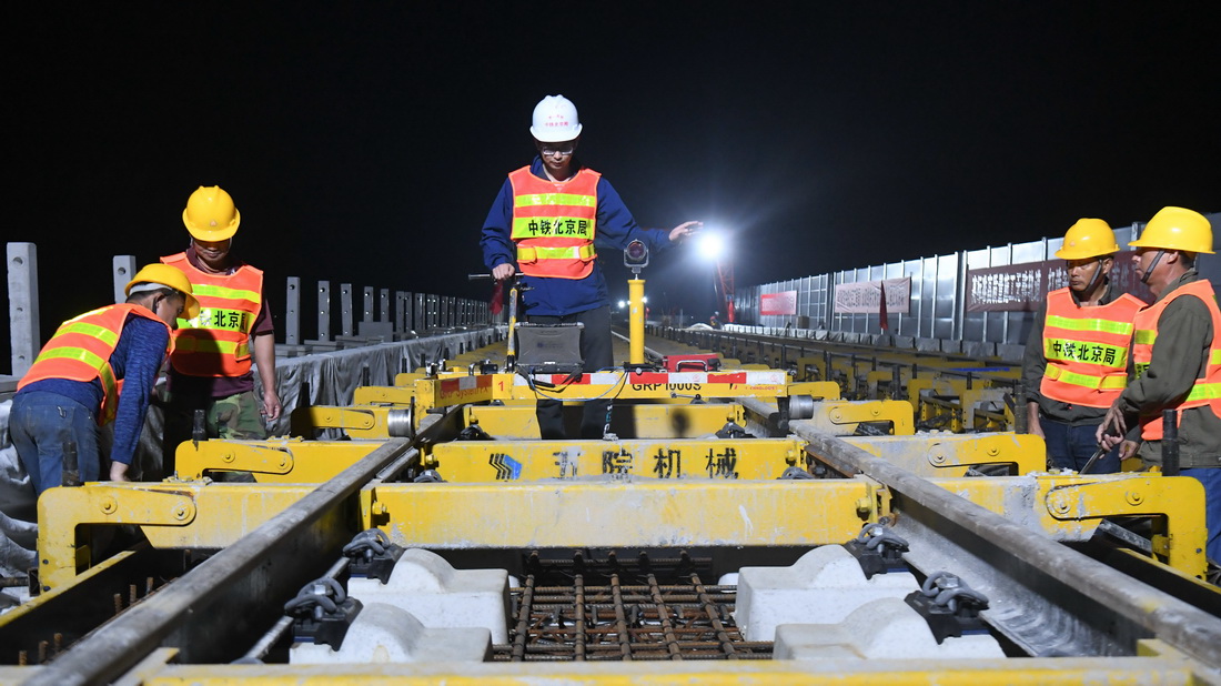 10月27日，在贵南高铁广西段八仙双线特大桥施工现场，施工人员使用轨道精调车对轨道进行精调。