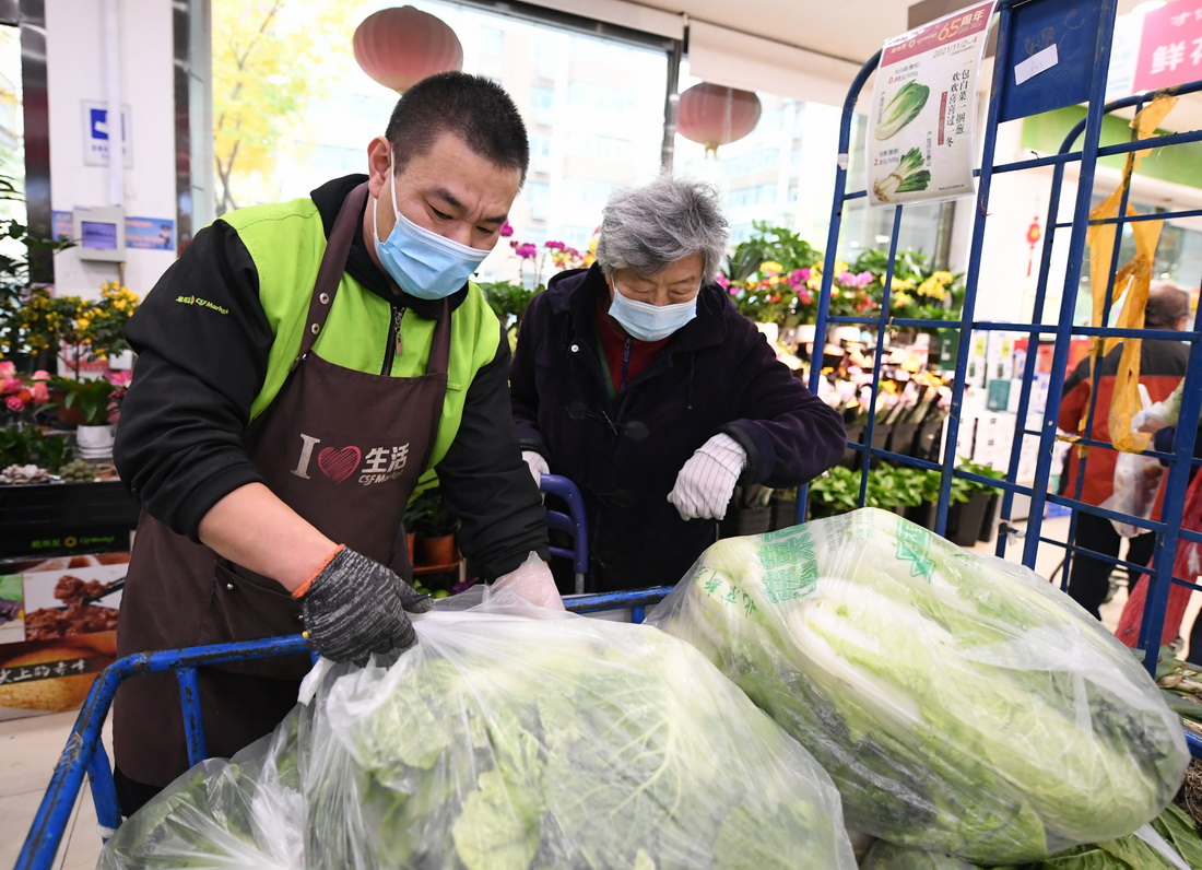 11月2日，在超市发科学城店，市民（右）选购冬储菜。