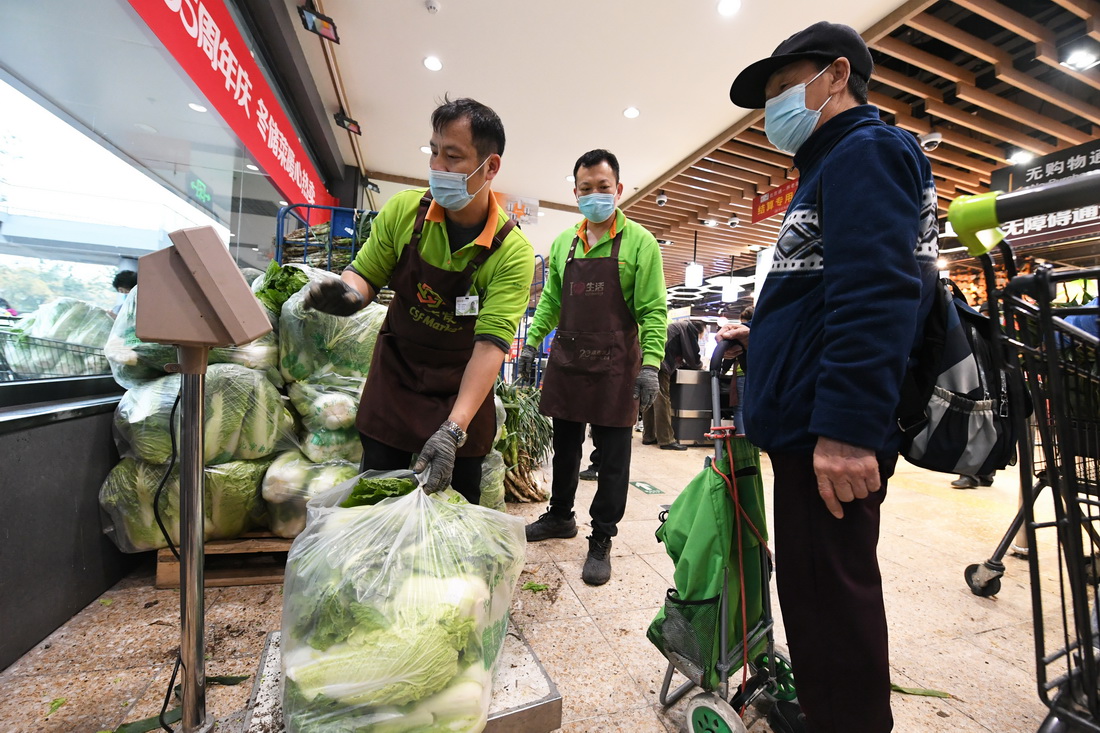 11月2日，在超市發雙榆樹店，工作人員（左一）為市民選購的大白菜稱重。