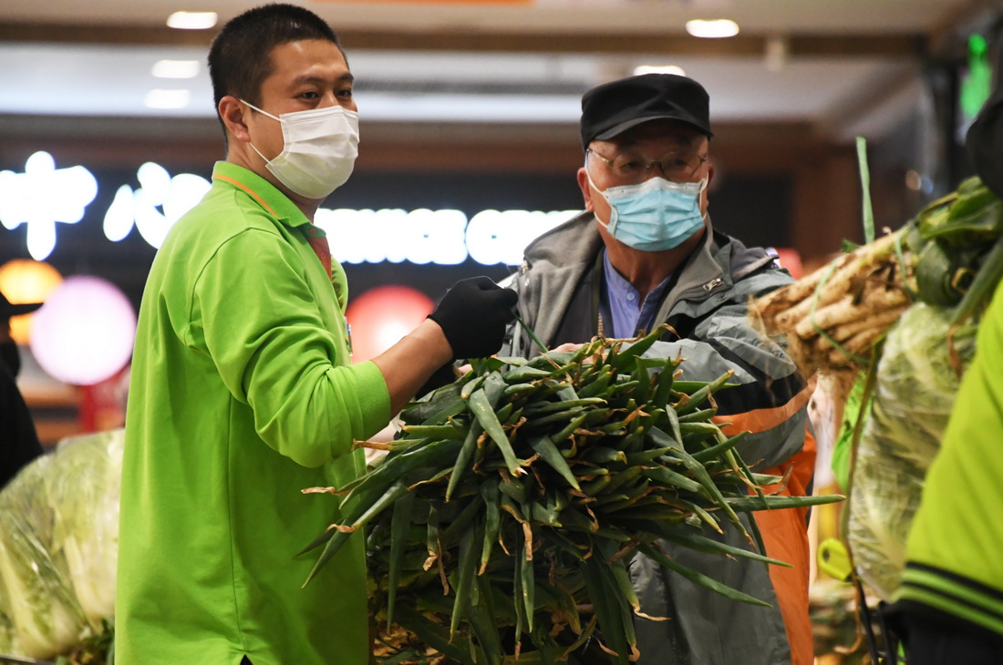 11月2日，在超市發雙榆樹店，市民（右）購買大蔥。