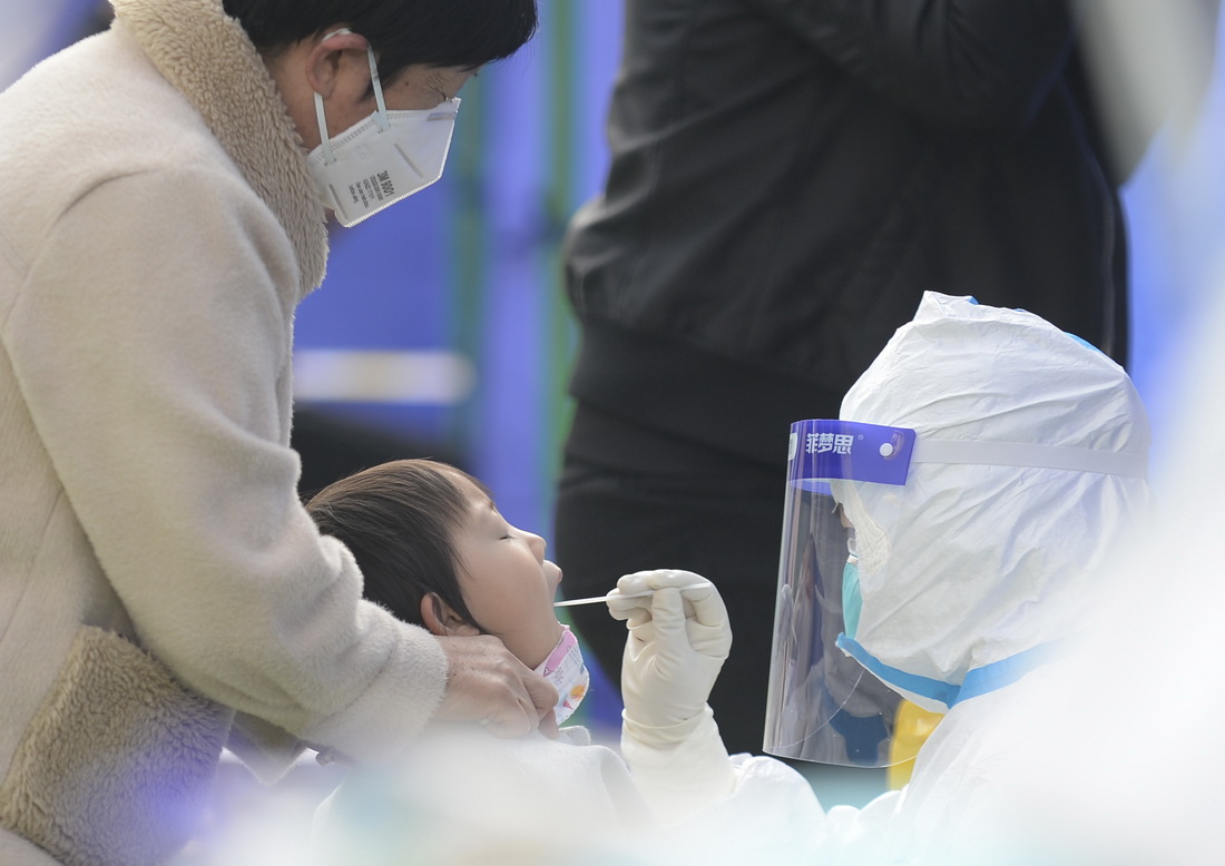 11月2日，在西宁市城西区行知小学操场检测点，家长带着孩子接受核酸采样。新华社记者 张曼怡 摄