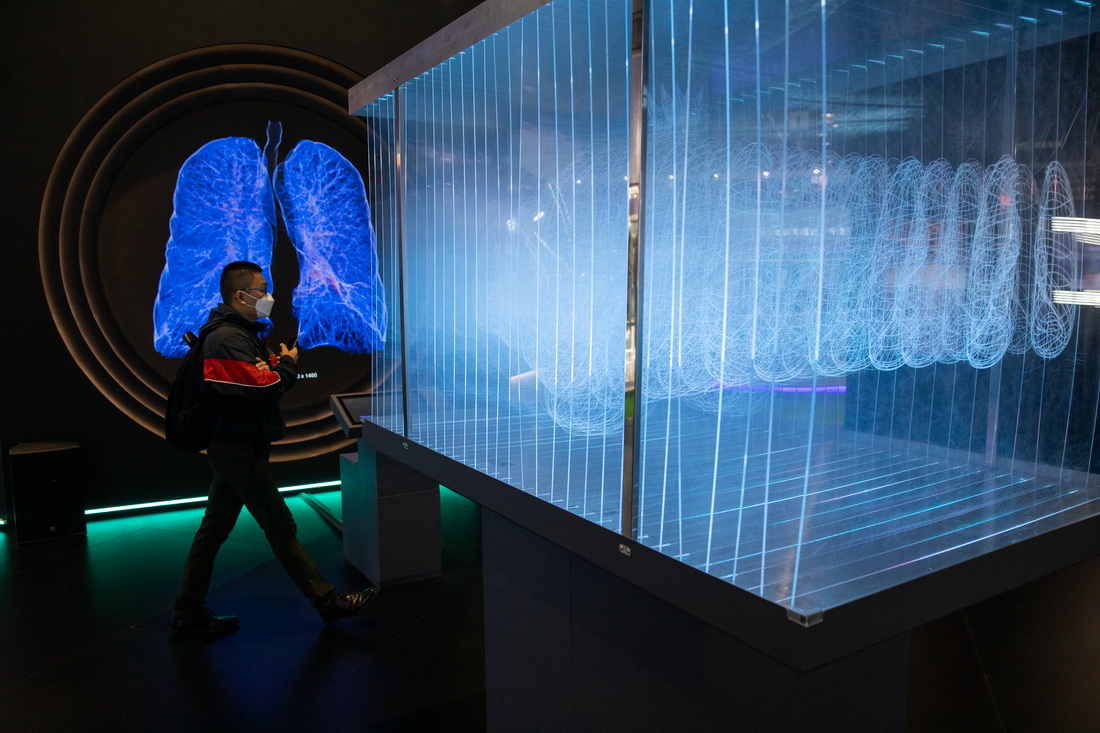 11月8日，在第四届进博会医疗器械及医药保健展区，参观者经过一台肺部成像演示装置。