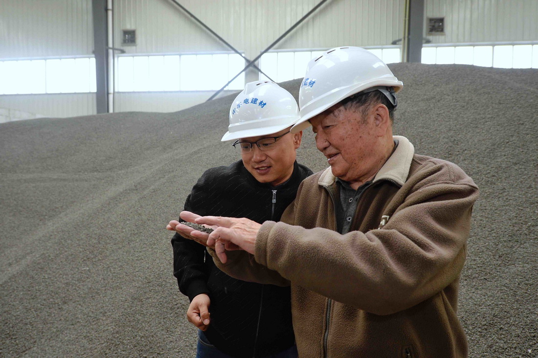 11月4日，王其昌（右）在聲屏障吸聲板生產廠與技術人員交流。