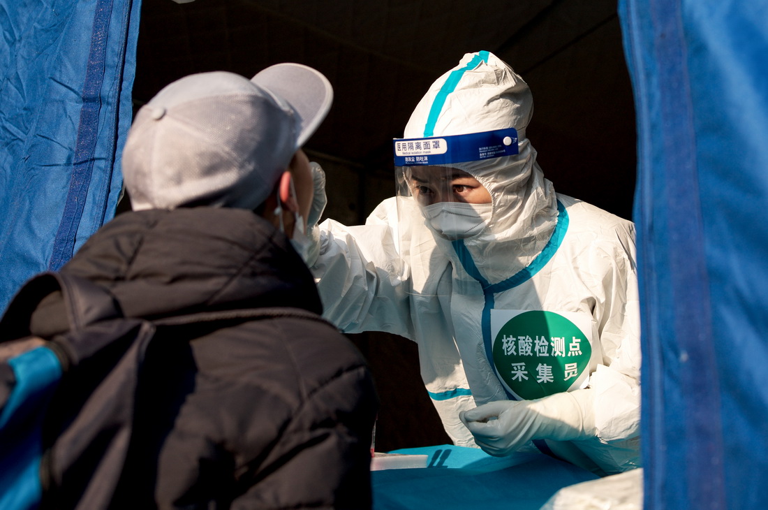 11月10日，在青海省西宁市城西区名都大厦采样点，医护人员为市民进行核酸采样。