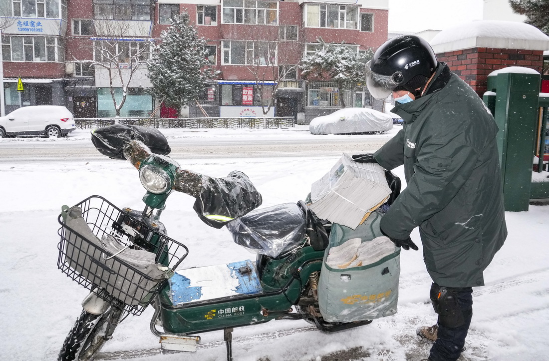吉林省長春市的一名中國郵政郵遞員在風雪中派送報紙（11月9日攝）。新華社記者 許暢 攝