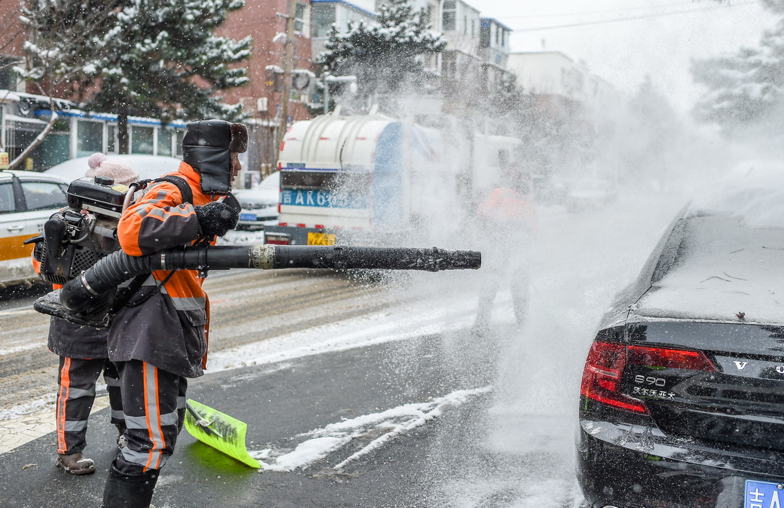 11月9日，在長春市朝陽區東中華路，環衛工人用工業吹風機為路邊車輛清雪。新華社記者 張楠 攝