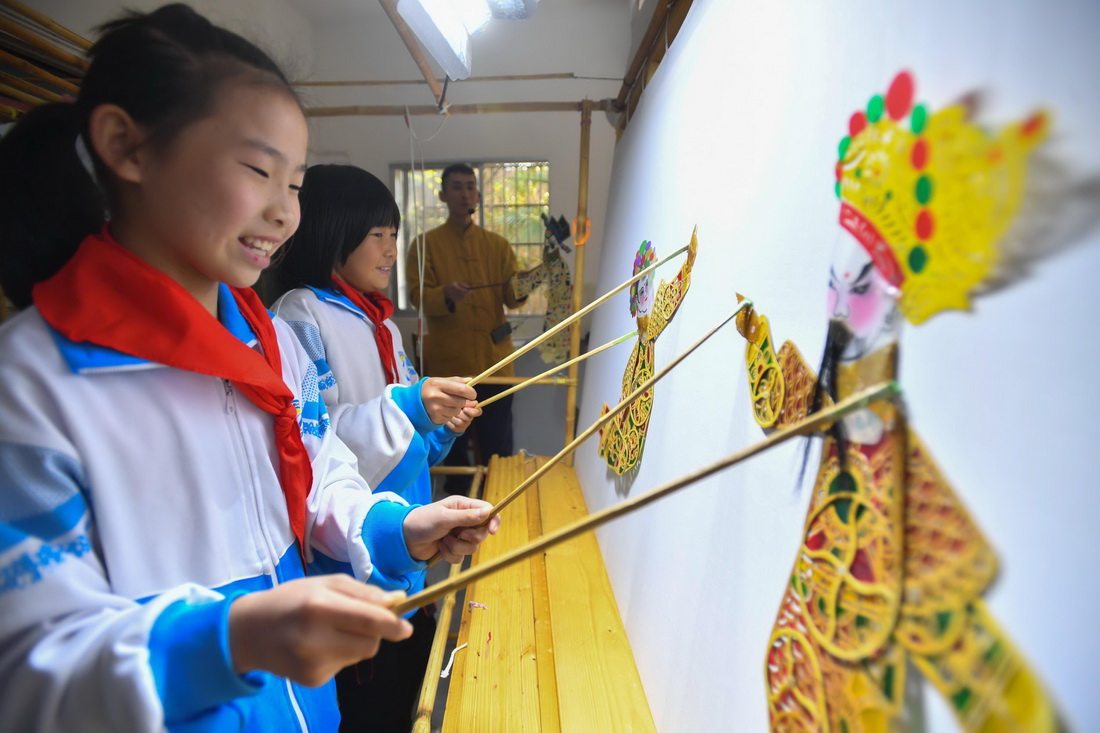 11月12日，在湖南省湘潭市雨湖区鹤岭镇南谷小学，学生们在体验纸影戏表演。