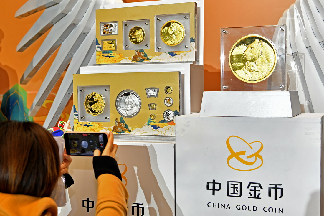 11月18日，在北京举行的2022中国壬寅（虎）年金银纪念币品鉴会上，与会者拍摄现场展示的纪念币。