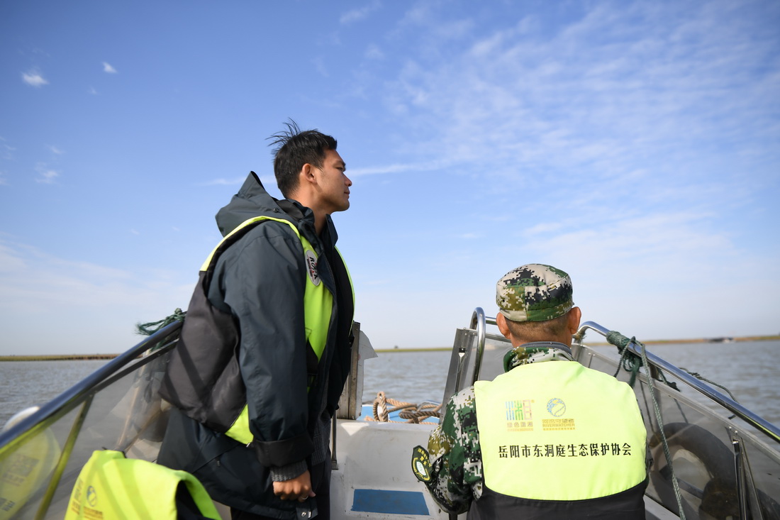 11月12日，何東順（左）和父親何大明在湖南省岳陽市東洞庭湖巡護。