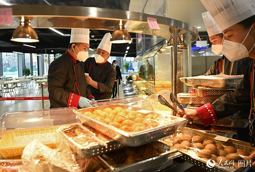 11月20日，北京冬奧村（冬殘奧村）開展場館運行測試，餐飲服務人員進行配餐服務。