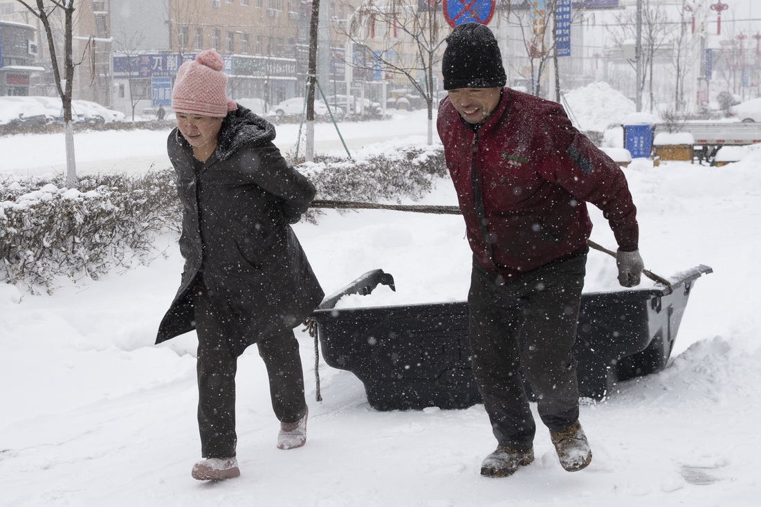 11月22日，在鸡西市鸡冠区一处小区外，市民自发清理积雪。新华社记者 张涛 摄