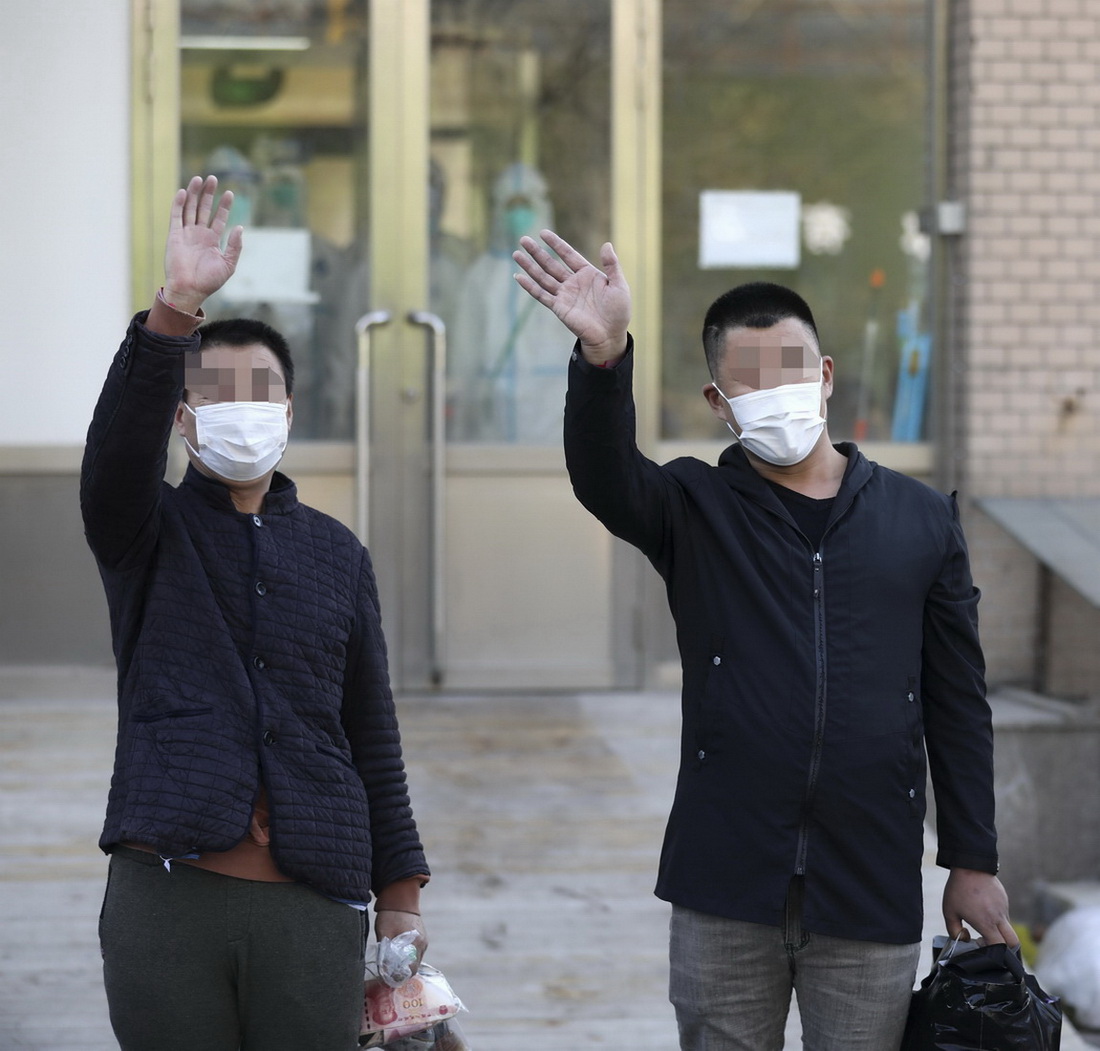 11月19日，兩名治愈患者走出隔離病房后招手致意。新華社記者 姚劍鋒 攝