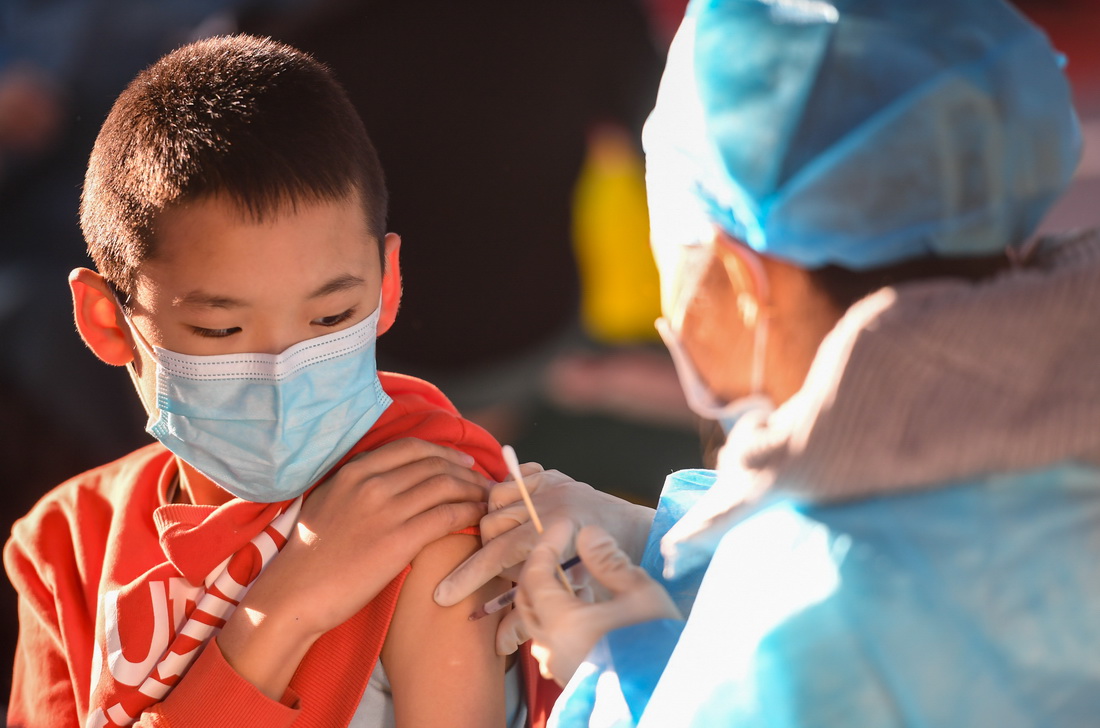 11月23日，在呼和浩特市回民区实验小学，医务人员为学生接种疫苗。