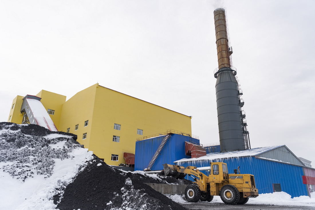 11月23日，在黑龍江省鶴崗市一供熱企業，工人在給輸煤系統添煤。
