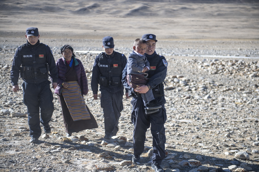普玛江塘边境派出所的移民管理警察帮助牧民旦增多杰的家人离开困在冰河里的小货车（11月20日摄）。新华社记者 孙瑞博 摄