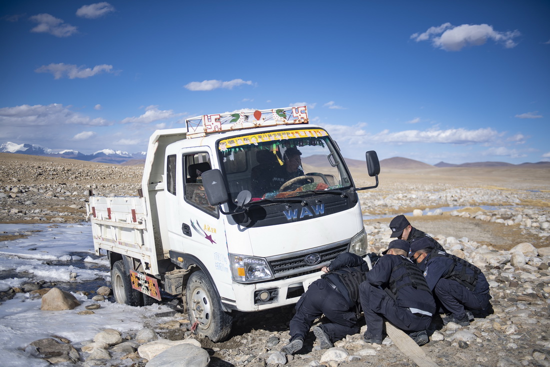 普玛江塘边境派出所的移民管理警察们帮助牧民旦增多杰的小货车从冰河脱困（11月20日摄）。新华社记者 孙瑞博 摄