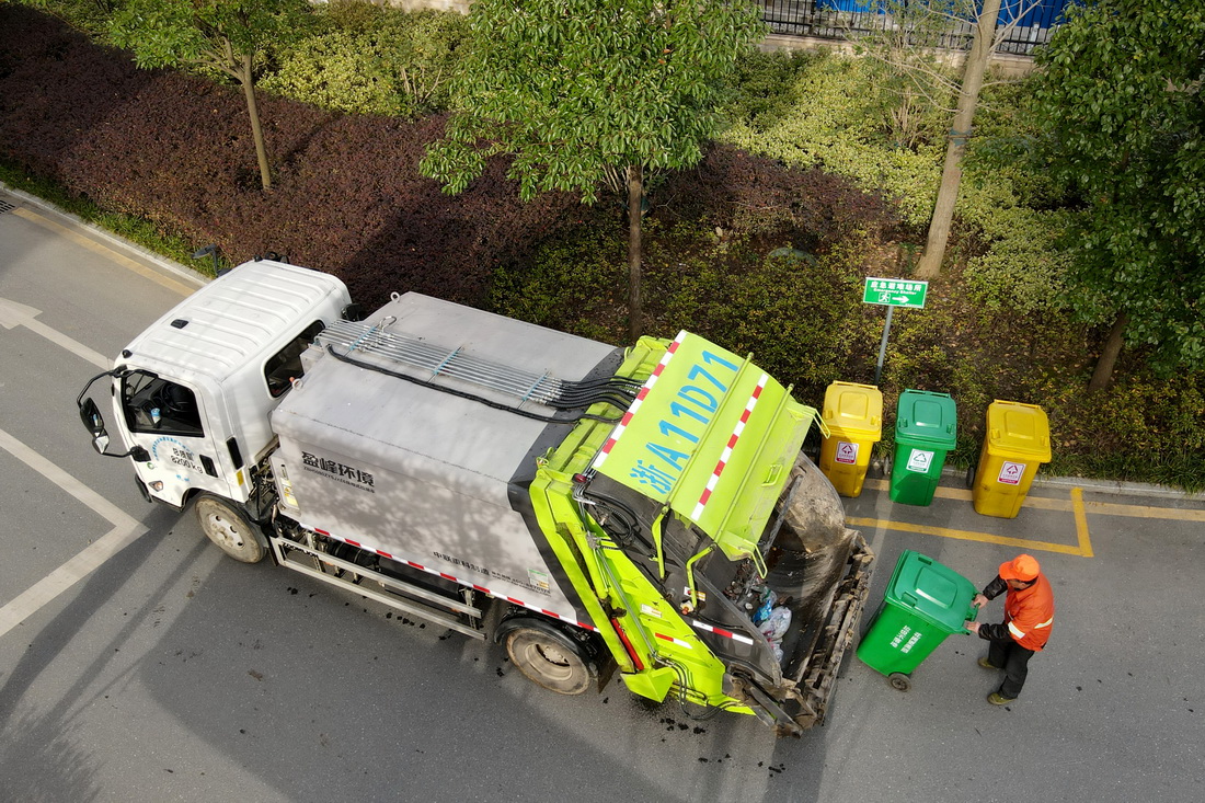 11月23日，在合肥市肥西县花岗镇一小区，工作人员将居民生活垃圾装上垃圾转运车。新华社记者 周牧 摄
