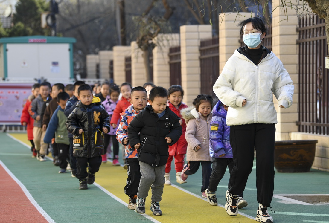 11月25日，宁夏银川市第四幼儿园老师带着小朋友在户外热身跑步。
