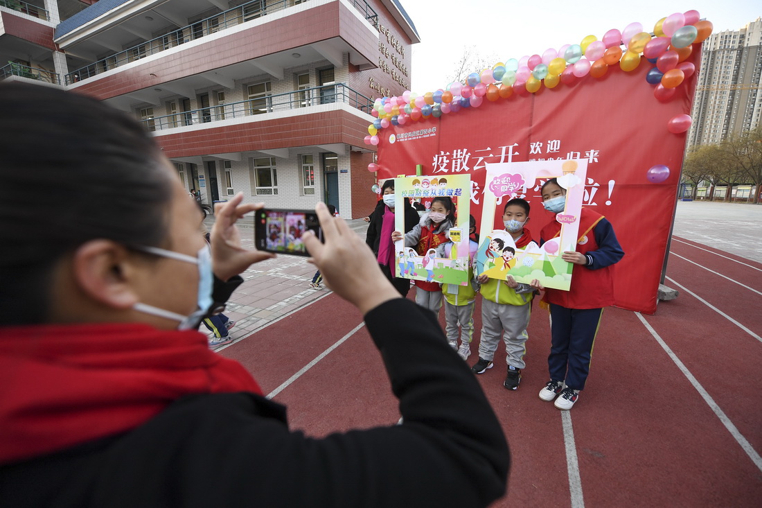 11月25日，宁夏银川市兴庆区第四小学学生在入校心愿墙前留影。