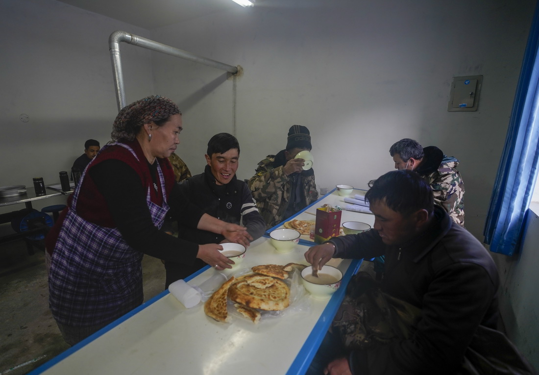 在新疆果子沟的一处牧民转场补给点里，牧民在吃饭（11月25日摄）。这个牧民转场补给点由霍城县政府管理，为转场牧民免费提供餐食、医疗服务和休息场所。