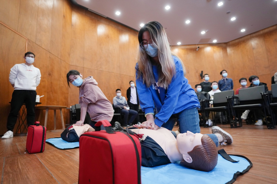 11月28日，清华大学计算机系的冬奥学生志愿者�X周杰（右）在急救技能培训上学习心肺复苏术。