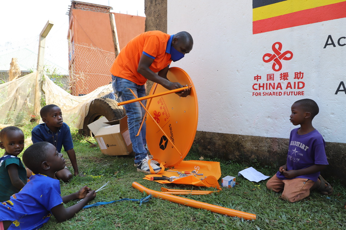 9月10日，技术人员在乌干达中部瓦基索区的布韦伦加村安装调试数字电视设备。中国企业四达时代集团承建的“万村通”项目让这里的村民看上了画面清晰而且免费的卫星数字电视节目。新华社记者 张改萍 摄