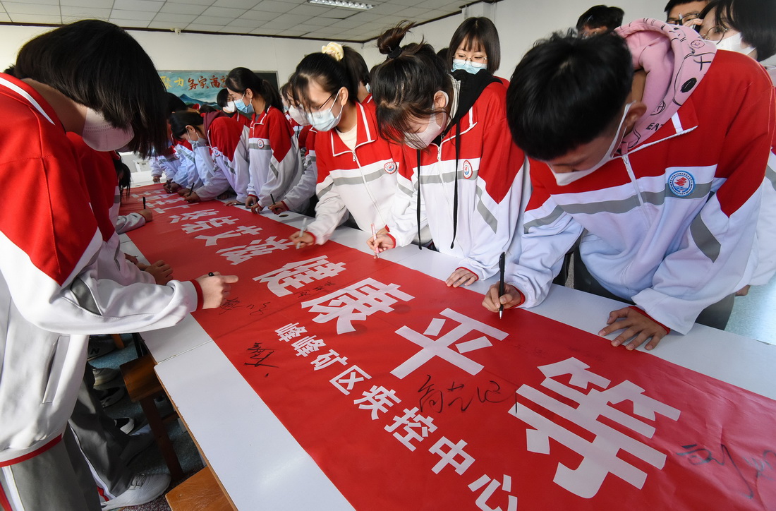 11月30日，河北省邯鄲市峰峰礦區職教中心的學生們在預防艾滋病主題活動橫幅上簽名。新華社發（郝群英 攝）