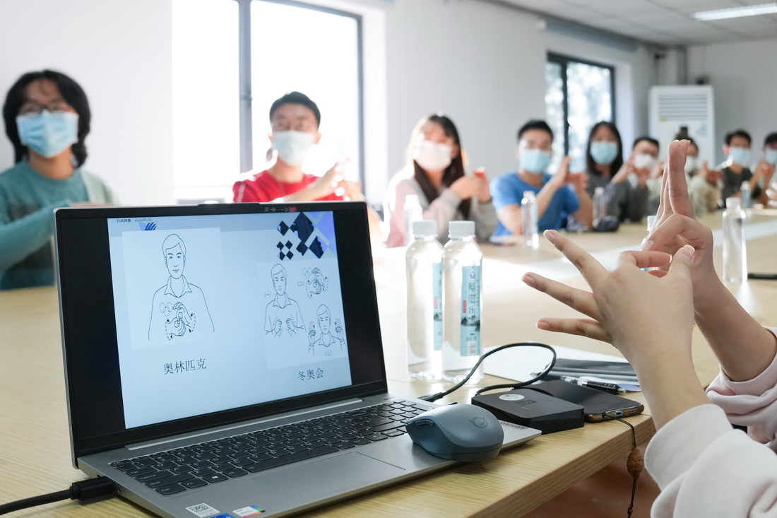 12月1日，在北京郵電大學，志願者在培訓老師的講解下學習手語。