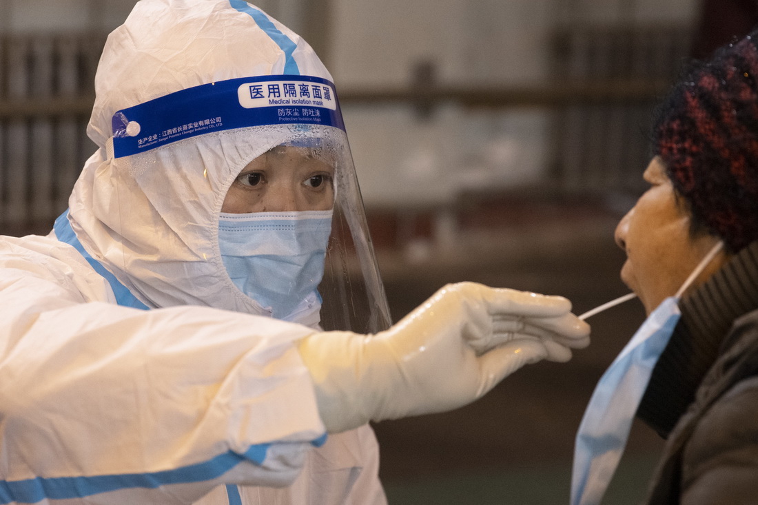 12月2日，在哈爾濱市香坊區安樂街道理工大學核酸檢測點，醫務人員進行核酸採樣。